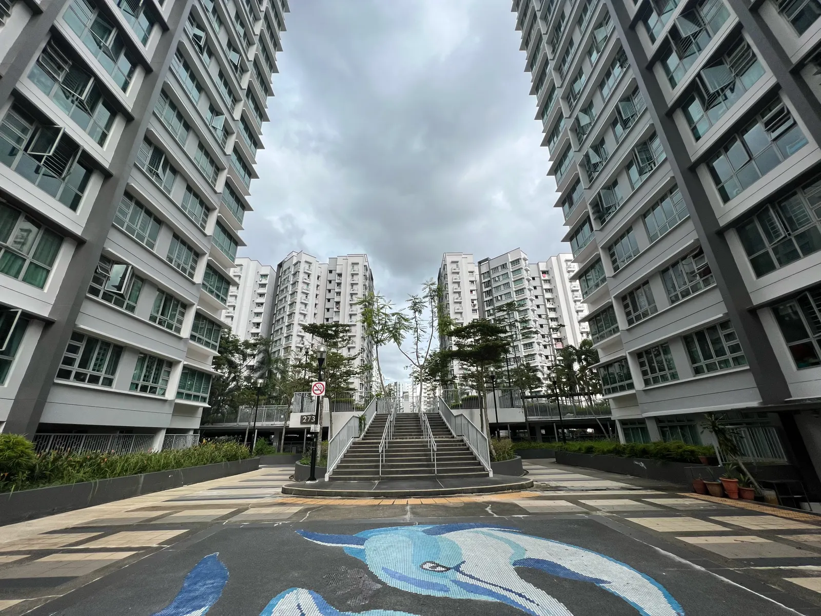 Edifícios residenciais do conjunto HDB Punggol Regalia, em Singapura, vistos a partir do espaço pedonal entre os blocos.